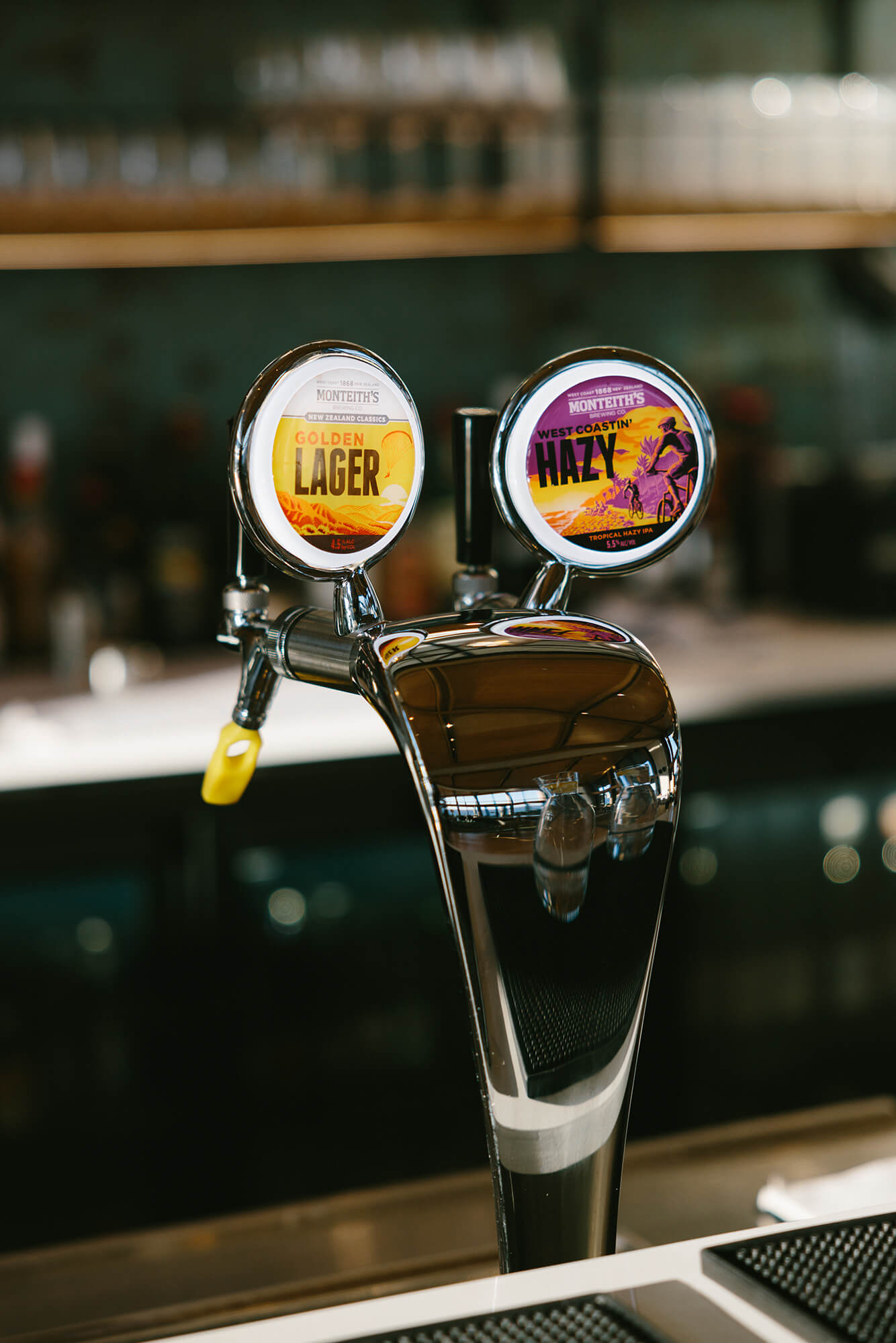 Shiney silver bar tap showing Golden Lager and Hazy beers on tap.