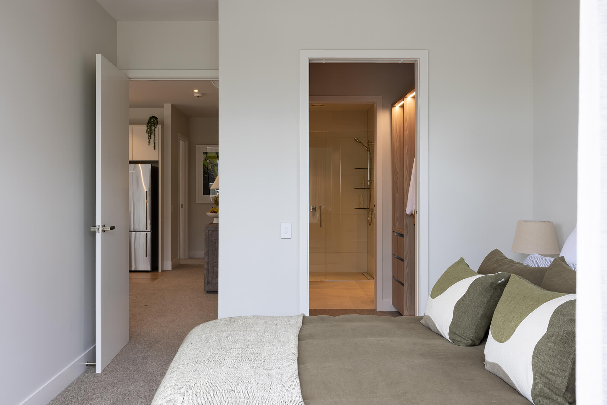 View through the well-lit walk-through wardrobe to the ensuite from the master bedroom.