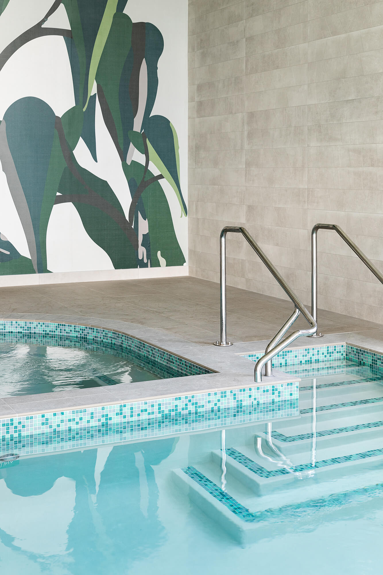 Turquoise tiled spa pool is adjacent to the entrance steps into the swimming pool.