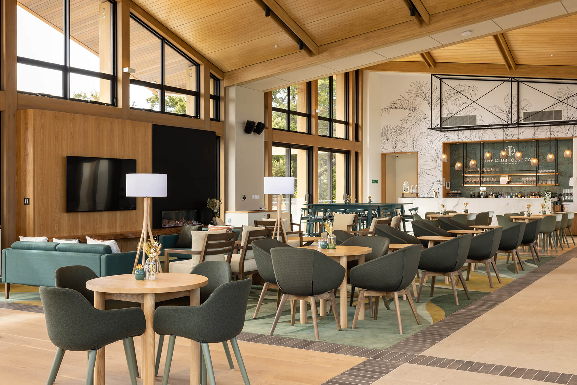 Comfortable fabric chairs around tables in The Clubhouse Café.